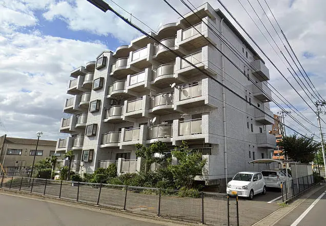 グレーの打ちっぱなしコンクリートと大きなガラス窓が特徴の5階建てデザイナーズマンション。
                                                