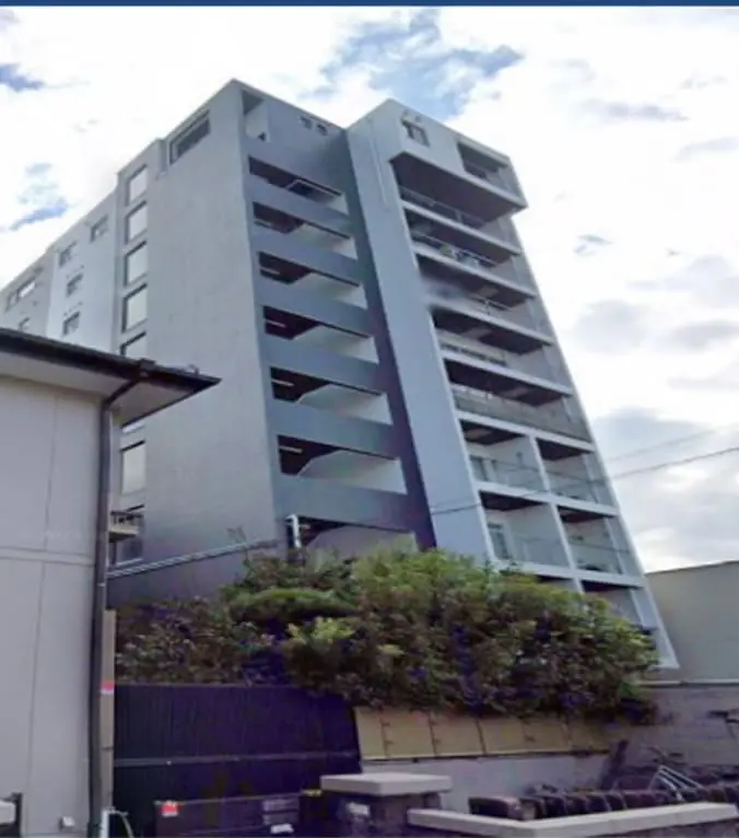 スタイリッシュなデザインの10階建てマンションで、バルコニーとダークカラーの外壁が特徴
                                                