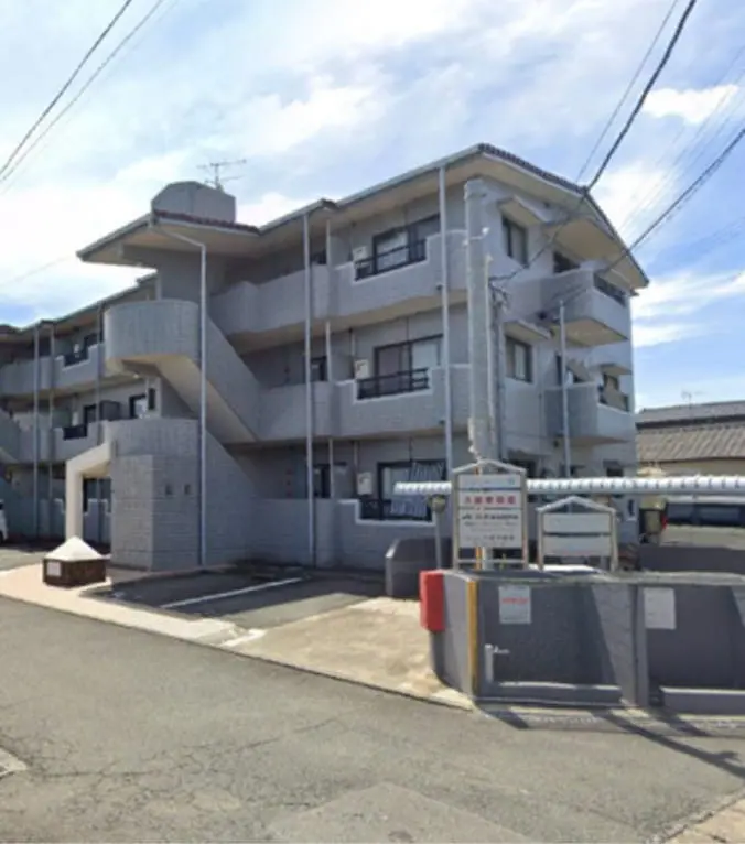 瓦屋根の3階建てマンションで、外壁はタイル張り、敷地内に駐車スペースが完備されている
                                                